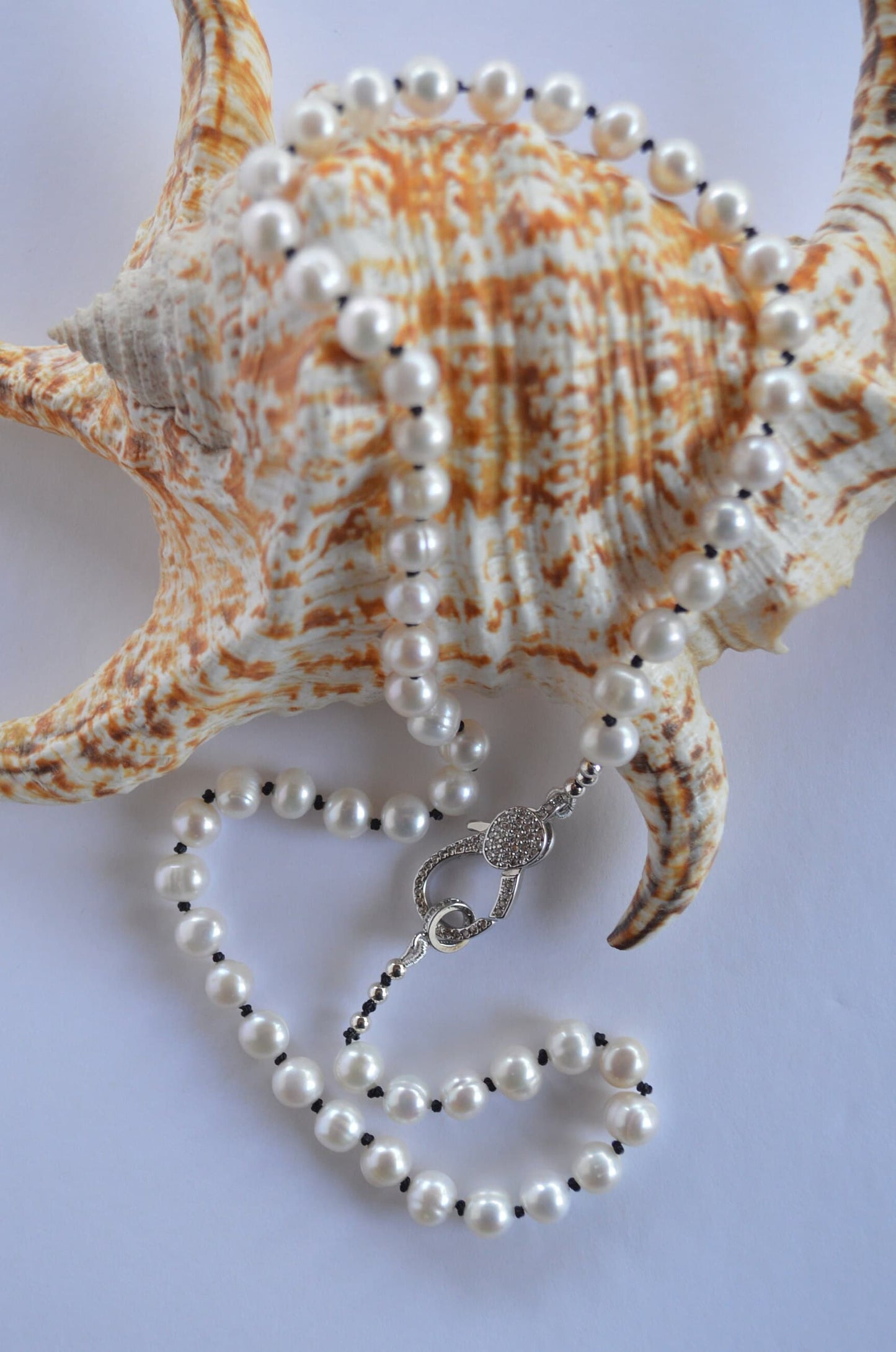 20" Freshwater Pearl Necklace Hand Knotted on Black Silk. Shiny CZ Lobster Claw Clasp That Can Be Worn in the Front or Back. 7-8 mm Pearls