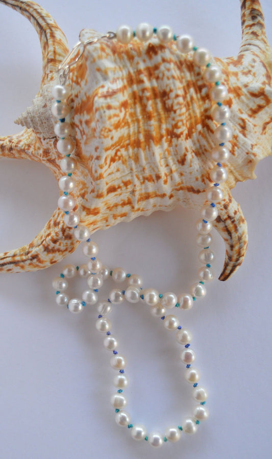 Luminescent 7-8mm Pearls Hand Knotted on Teal and Purple Silk Thread.  Hand Forged Sterling Silver Hook and Eye Clasp. 20"