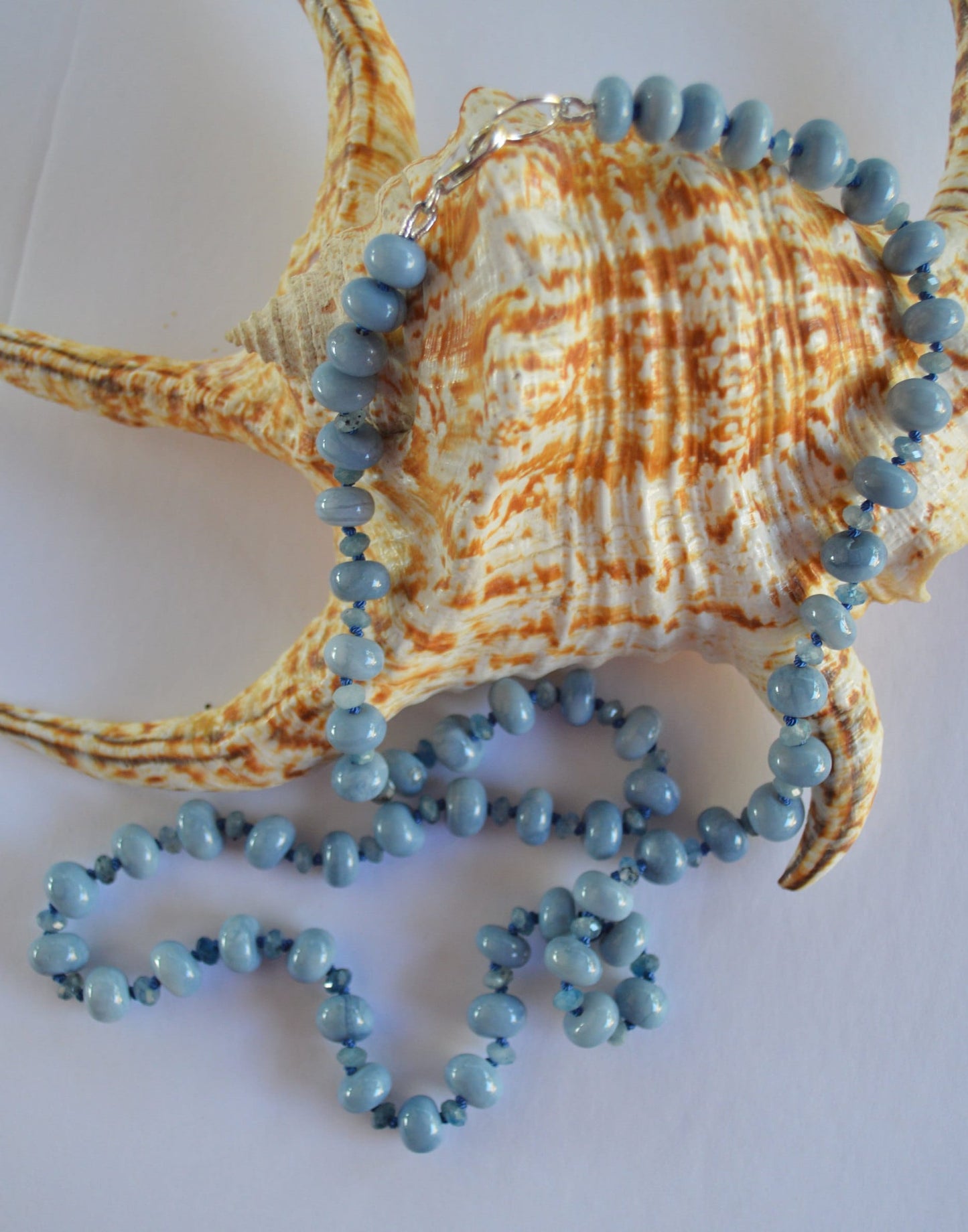 Sky Blue Smooth Opal Rondelles and Stormy Blue Aquamarine Gemstones Hand knotted on Blue Silk.  Sterling Lobster Clasp. 22"