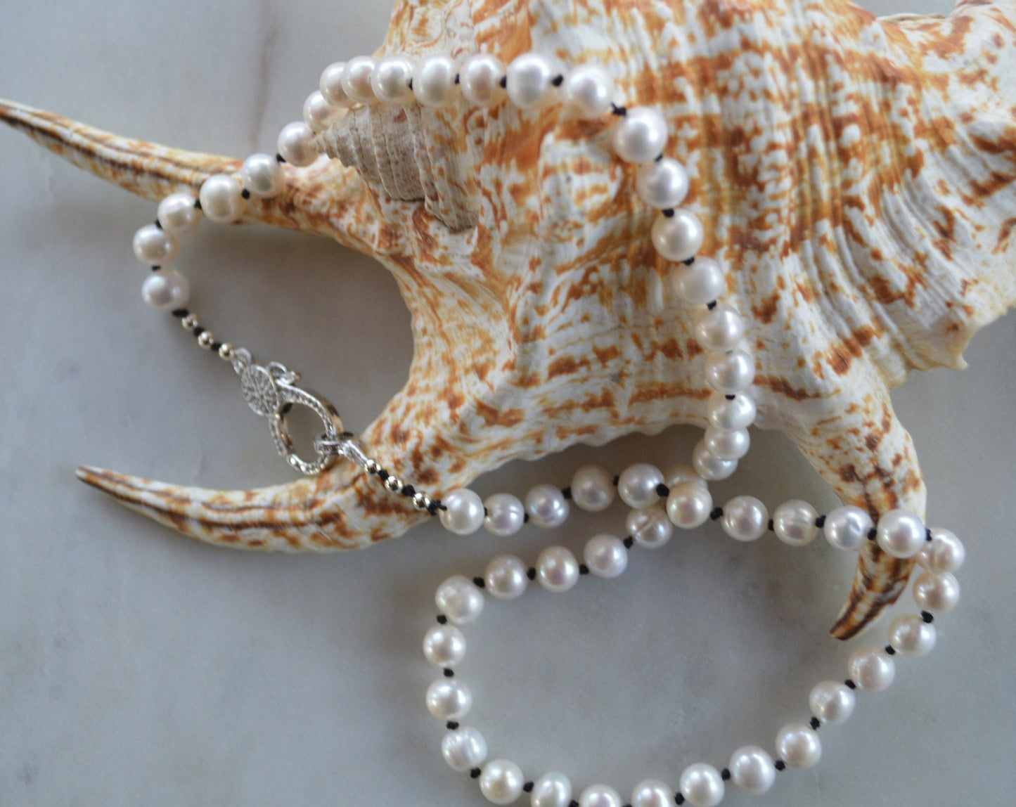 20"  Freshwater Pearl Necklace Hand Knotted on Black Silk. Shiny CZ Lobster Claw Clasp That Can Be Worn in the Front or Back. 7-8 mm Pearls