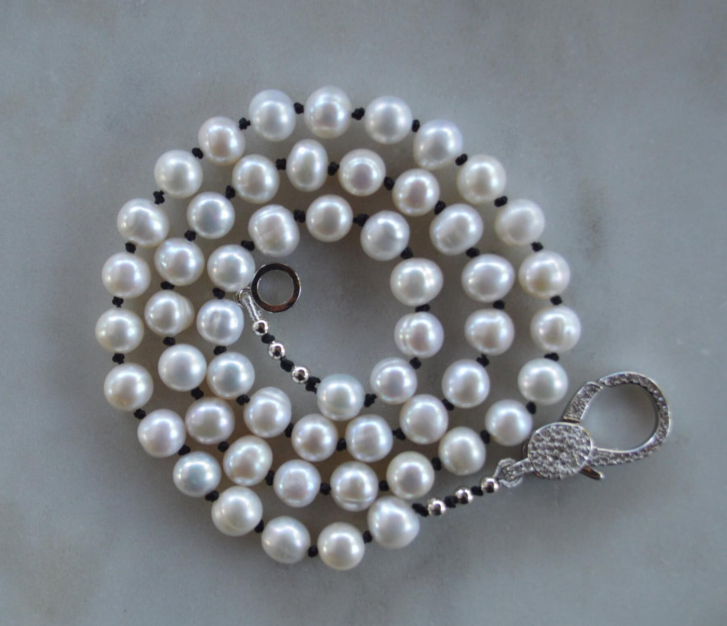 20"  Freshwater Pearl Necklace Hand Knotted on Black Silk. Shiny CZ Lobster Claw Clasp That Can Be Worn in the Front or Back. 7-8 mm Pearls