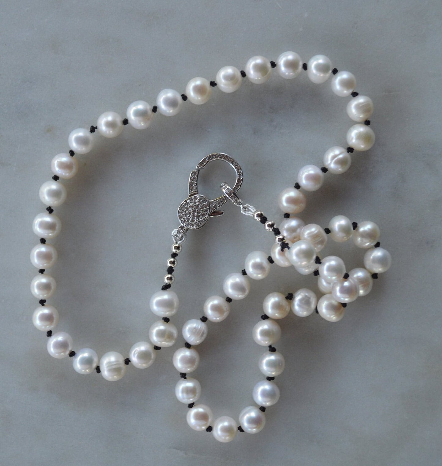20"  Freshwater Pearl Necklace Hand Knotted on Black Silk. Shiny CZ Lobster Claw Clasp That Can Be Worn in the Front or Back. 7-8 mm Pearls