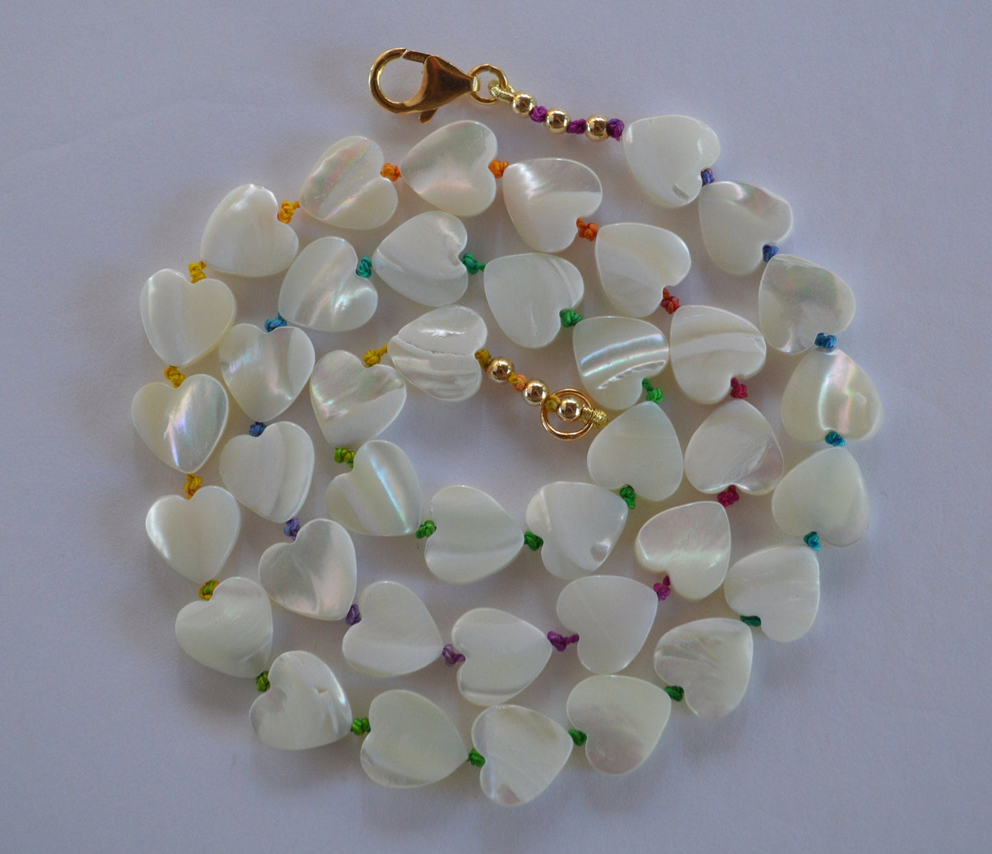 Shimmery and Iridescent Necklace.  Mother of Pearl Heart Beads Knotted on Multicolored Silk.  GF Italian Lobster Claw and Beads. 19"