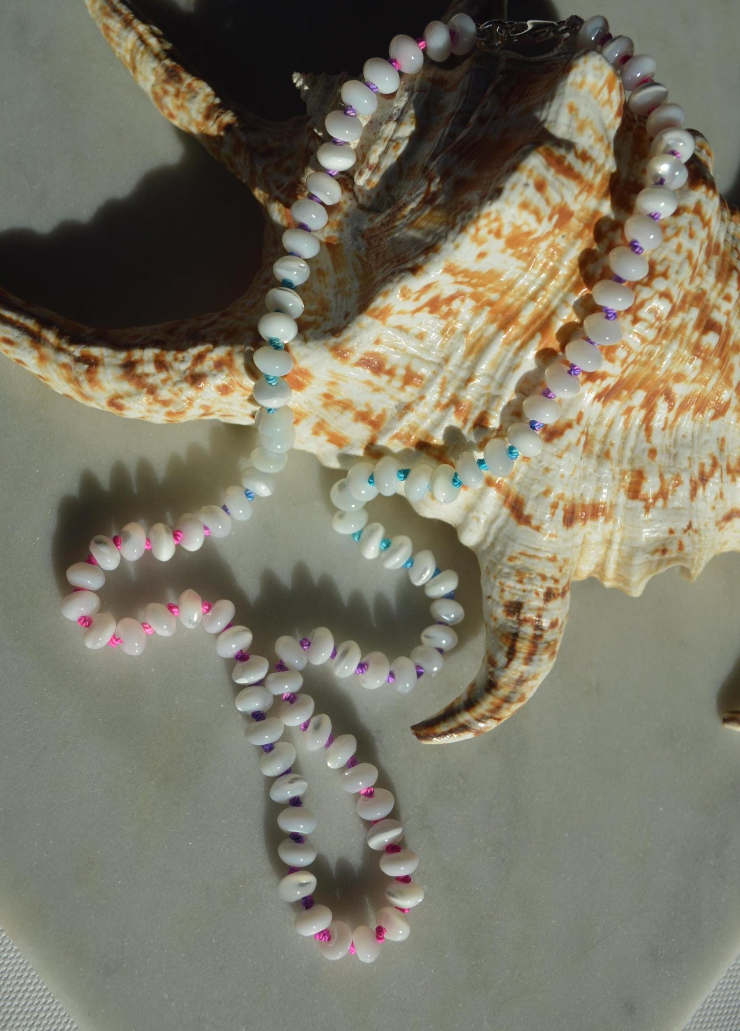 19" Mother of Pearl Rondelles Hand Knotted on Custom Fushia, Teal and Purple Silk. Sterling Lobster Clasp and Beads