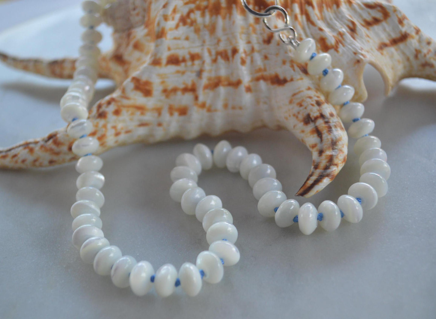 Shimmery Mother of Pearl 8mm Rondelle Necklace Hand Knotted on Sky Blue Silk.  Hand Forged Sterling Hook and Eye Clasp