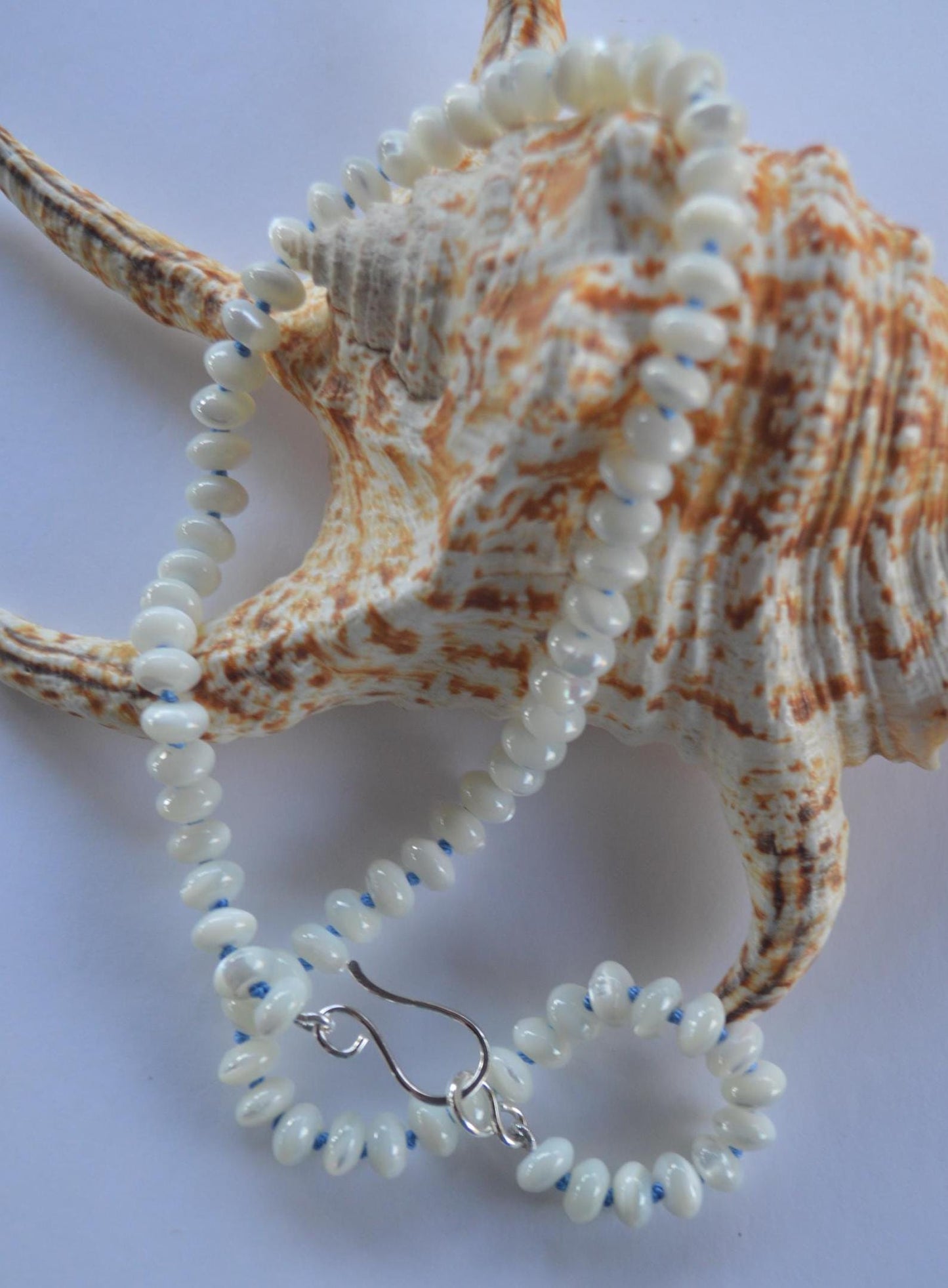 Shimmery Mother of Pearl 8mm Rondelle Necklace Hand Knotted on Sky Blue Silk.  Hand Forged Sterling Hook and Eye Clasp