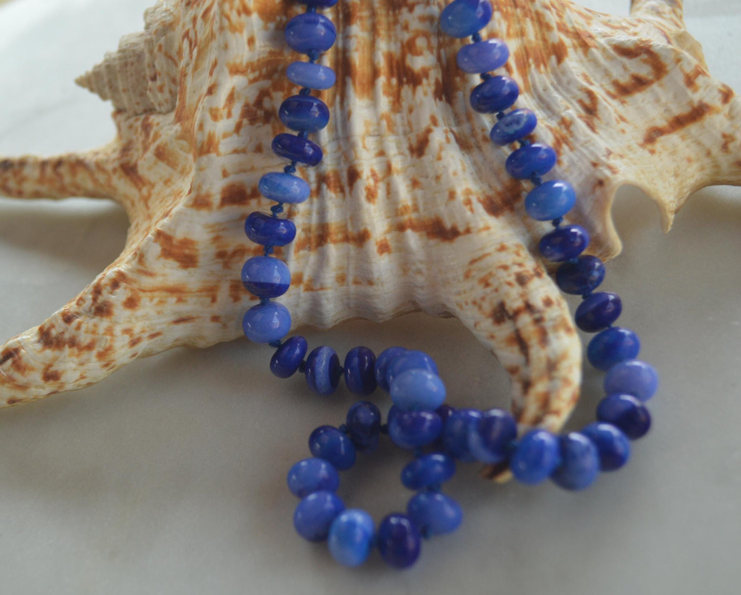 18" Cobalt Blue Smooth Opal Rondelles Hand Knotted on Dark Blue Silk.  This Versatile Piece is Finished with a Sterling Silver Lobster Clasp